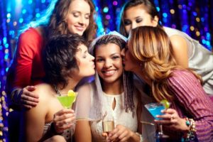 Beautiful female friends congratulating the bride and kissing her