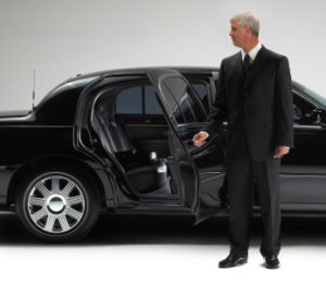 Chauffeur opening Limo car door. Isolated against white.